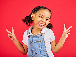 Image showing Happy, peace sign and wink with portrait of girl for summer, happiness and funny face. Meme, fashion and smile with child and hand gesture for youth, comedy and positive in red background studio