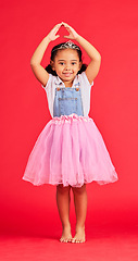 Image showing Ballerina dance, portrait and child in princess dress for fantasy, red background and studio. Happy girl in ballet skirt, fairytale clothes and fashion crown with smile, playful energy and happiness