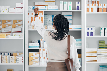 Image showing Pharmacy, black woman and pills stock of a customer shopping for medicine, wellness cream or product. Female back, shop and drugs clinic with a person looking for health, medical and shelf products