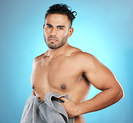 Image showing Cleaning, towel and portrait of a man after a shower isolated on a blue background in a studio. Sexy, grooming and muscular model on a backdrop after washing body for hygiene, skincare and health