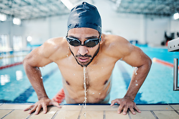 Image showing Tired, breathing and man swimming for fitness, training and race in a stadium pool. Strong, sports and face of an athlete swimmer doing cardio in the water for a workout, sport and competition