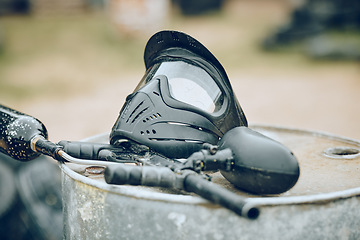 Image showing Equipment, paintball and gun with helmet ready for competition, match or game outdoors in battlefield. Tools, safety gear and recreation weapon for fun or extreme sport and game outdoors