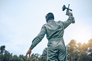 Image showing Paintball gun, winner person and blue sky mockup for success in battlefield game, outdoor sports or adventure. Shooting, war and fitness man in safety gear for military training, action and winning