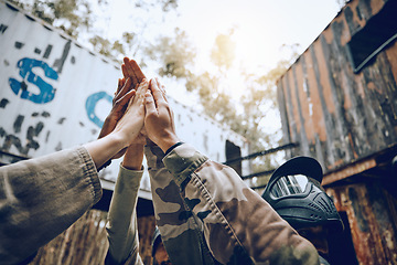 Image showing Paintball, team and high five for celebration, achievement and victory while on vacation, playful or fun. People, group and gesture for accomplishment, partnership or collaboration to win and success