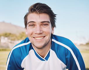 Image showing Football player, portrait and smile on field for training, fitness and workout goals, mission and strategy on blue sky. Happy soccer athlete, person or man face for contest, game and outdoor sports