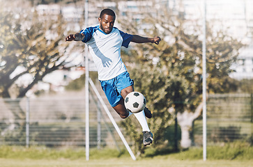 Image showing Sports, soccer and man in action with ball playing game, training and exercise on outdoor field. Fitness, workout and male football player kicking, running and score goals, winning and competition