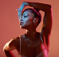 Image showing Blue light, beauty and black woman profile feeling sexy and mystical with studio lights. Brown background, isolated and creative face glow of a female model with colorful lighting and glamour pose