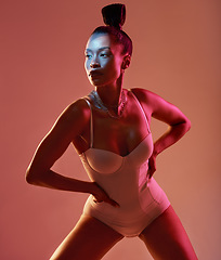 Image showing Art, beauty and neon with a model black woman in studio posing in underwear on an orange background. Aesthetic, creative and fashion with an attractive young female standing on a kaleidoscope wall