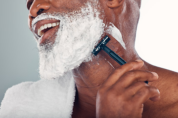 Image showing Black man shaving, face and cream with razor, healthy skin with beauty and grooming isolated on studio background. Facial hair removal, happy elderly person and hygiene with skincare and wellness