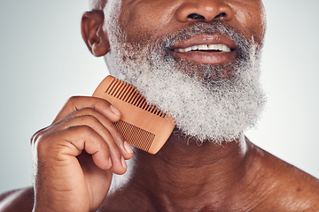 Image showing Grooming, comb and barber with beard of black man for beauty, hygiene and skincare. Self care, facial hair and maintenance with senior model for health, wellness and cleaning in studio background