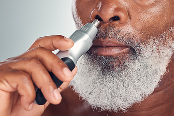 Image showing Black man, grooming and nose hair removal with an electric trimmer for shave, beauty and skin care. Face of African person with tools for nasal hygiene, facial routine or maintenance grey background