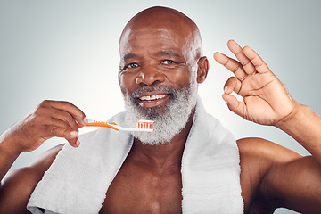 Image showing Black man, toothbrush and yes hand sign, dental and brushing teeth with hygiene isolated on studio background. Mouth care, healthcare and wellness with toothpaste, cleaning and oral health ok