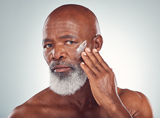 Image showing Face cream, skincare and senior man in studio for wellness, beauty and grooming against grey background. Facial, skin and elderly model relax with luxury, cosmetics and wrinkle product while isolated