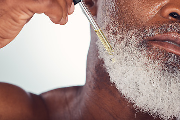 Image showing Closeup, black man and serum for beard, cosmetics and hygiene for wellness, natural beauty and grey studio background. Senior male, mature guy and oil for hair care, grooming routine and treatment