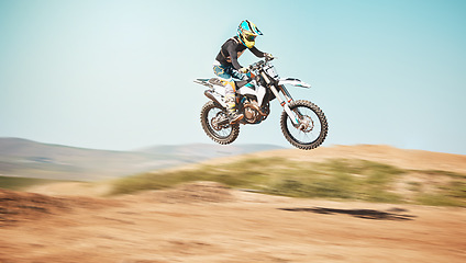 Image showing Motorcycle, offroad driving and air jump in desert, blue sky and freedom. Driver, cycling and power stunt on dirt track, competition and motorbike performance on adventure course for fast action show