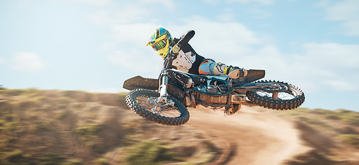 Image showing Motorcycle, fearless man and motorcross jump in desert, blue sky and freedom. Driver, cycling and offroad freedom of sports competition, motorbike performance or adventure course for fast action show