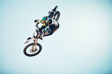 Image showing Motorbike, outdoor jump and man on blue sky mockup for speed challenge, sports risk and fearless skill. Driver, air stunt and biker with energy, freedom and performance talent of motorcycle adventure