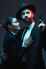 Image showing Couple, fashion or gun on dark studio background in secret spy, isolated mafia safety or crime lord security. Gangster love, woman or model with weapon in stylish, trendy or fashion clothes aesthetic