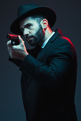 Image showing Gangster, suit and shooting gun on dark studio background in secret spy, isolated mafia leadership and crime lord security. Model, man and hitman aiming weapon in formal or fashion clothes aesthetic