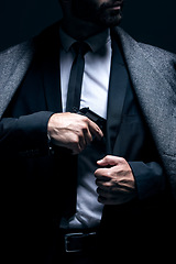 Image showing Bodyguard, hands or gun in suit jacket on studio background in dark secret spy or isolated mafia leadership. Gangster, man or criminal hiding weapon in formal, crime lord or fashion clothes aesthetic