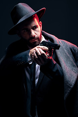 Image showing Bodyguard, suit or shooting gun on studio background in dark secret spy, isolated mafia leadership or crime lord security. Model, man and gangster aiming weapon in formal or fashion clothes aesthetic