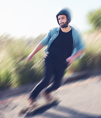 Image showing Motion blur, skateboard and balance with a sports man training outdoor on an asphalt street at speed. Skating, speed and movement with a male skater on a road for fun, freedom or training outside