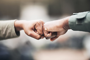 Image showing People, hands and fist bump for agreement, deal or trust in partnership, unity or support on a blurred background. Hand of team touching fists for community, teamwork or collaboration in the outdoors