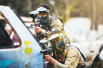 Image showing Paintball, shooting and people in action competition, game or match as a competitive team on a battleground. Aim, gun and player or teamwork of group in extreme sports with camouflage and safety mask