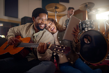 Image showing Musician, guitar and couple with a tablet for music, email and learning sound in a dark studio. Happy, reading and black man and woman streaming on technology with a musical instrument at night