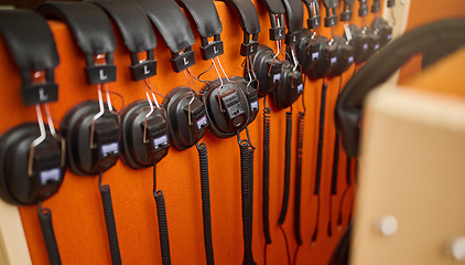 Image showing Radio, music and headphones hanging on a wall for a dj, podcast or audio production in the studio. Sound, electronics and equipment for streaming songs, listening to a track or musical accessory