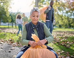 Image showing Trash, volunteer and senior woman cleaning garbage, pollution or waste product for environment support. Plastic bag, eco friendly community service and NGO charity team help with nature park clean up