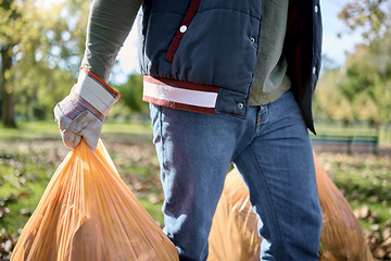 Image showing Trash, volunteer hands and man cleaning garbage, pollution or waste product for environment support. Plastic bag container, NGO charity service and eco friendly person help with nature park clean up