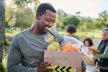 Image showing Food, donation and man in park with smile and grocery box, happy, healthy diet at refugee feeding project. Fresh fruit, charity donations and help to feed people, support from farm volunteer at ngo.
