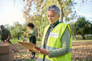 Image showing Volunteer, clipboard and senior woman with checklist in park for charity, planning and organized donation. Community, service and elderly lady checking list in forest for environment, help or project