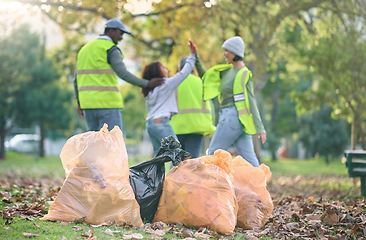 Image showing Volunteer, child and people high five while cleaning park with garbage bag for a clean environment. Group or team help with trash for eco friendly lifestyle, community service and recycling in nature