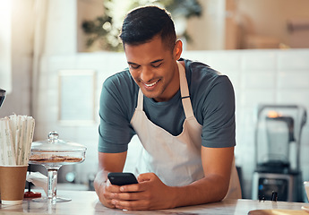 Image showing Phone, small business and barista man in cafe shop for networking, online sales management and ecommerce. Happy waiter, cashier or worker person on smartphone, technology application in restaurant