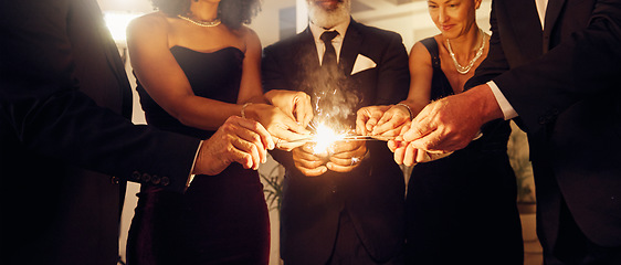 Image showing Fire, sparklers and people at a luxury party, event or celebration for new year with formal outfit. Celebrate, matches and group of friends in classy clothes at a black tie gala, banquet or dinner.