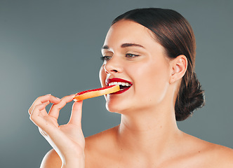 Image showing Fruit, smile and woman with a grapefruit for nature and wellness aesthetic in a studio. Model health eating, beauty and natural skincare of person with red lipstick hungry for vitamin c nutrition