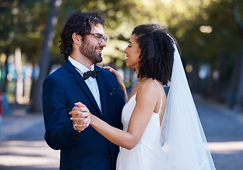 Image showing Interracial wedding, couple and dancing in street with excited smile, happiness or future. Black woman bride, man and diversity at outdoor marriage for love, dance or eye contact in sunshine by trees