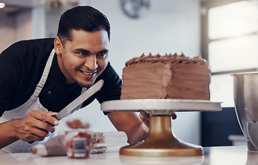 Image showing Baking, small business and happy man icing cake with chocolate frosting and piping bag in bakery with smile. Sweets, skill and baker decorating dessert for birthday event and chef working in kitchen.