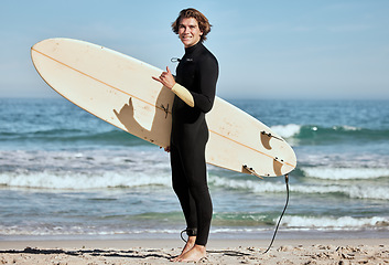 Image showing Man, surfer and surfboard at the beach for training exercise or fitness workout in the outdoors. Portrait of happy sports professional with smile showing hand gesture for hang loose ready for surfing