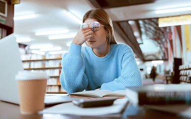 Image showing Woman student, fatigue with headache and university burnout, stress for paper deadline or study for exam in library. Campus, college and tired studying with scholarship problem and mental health pain