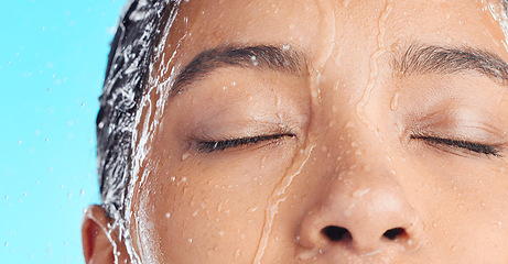 Image showing Shower water, face cleaning and black woman washing with liquid for hydration, beauty healthcare or skincare hygiene. Self care studio, spa salon and relax closeup model isolated on blue background