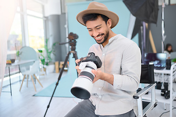 Image showing Happy, photographer and man with camera in studio, smile and excited before a photo shoot. Backstage, photography and asian guy relax during profession, shooting for design and creative career