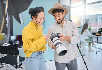 Image showing Camera, creativity and photographer talking to a model while looking at pictures from a photoshoot. Photography, creative and young cameraman choosing a image with a woman in creative artistic studio