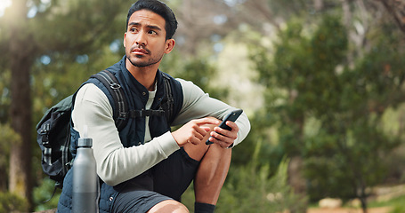 Image showing Nature hiking man, typing phone and sitting on rock for rest, break or relax with backpack outdoor. Forest adventure, woods explorer and smartphone for coordinate direction on gps navigation by trees