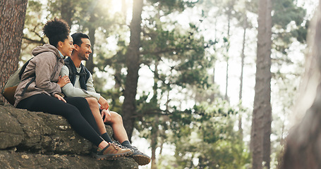 Image showing Nature, hiking and a couple relax on adventure trail in forest and sitting on a rock. Health, happy man and woman pointing at natural landscape while relaxing in woods with trees, fitness and freedom