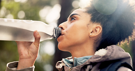 Image showing Nature, health and a woman hiking and drinking water on adventure trail with trees in summer. Health, fitness and freedom, black woman in forest with a drink of water walking in a natural landscape.