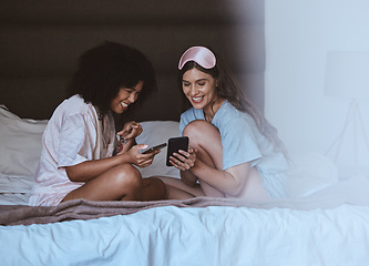 Image showing Woman, friends and phone with smile for social media, networking or funny meme on bed together at home. Happy women smiling, laughing and relaxing for post or smartphone entertainment in the bedroom