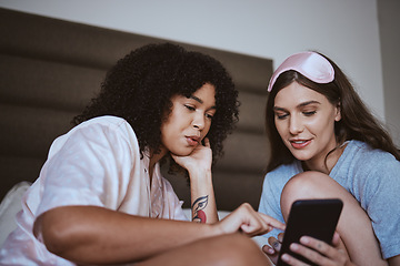 Image showing Phone, sleepover and friends in bed talking, bonding and networking on social media, mobile app or internet. Fun, technology and women browsing on a website with a cellphone in a bedroom at home.